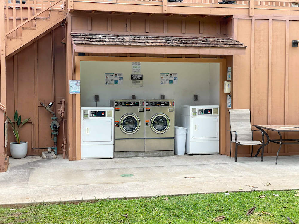 Image of an outdoor laundry area with two washing machines and two dryers.