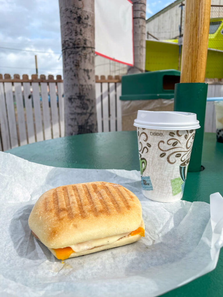 Image of a freshly made breakfast sandwich and a to go cup of coffee at Hula Bean Cafe on Moloka'i.