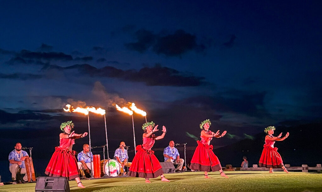 Image of four women wearing red costumes while dancing the ancient style of hula.