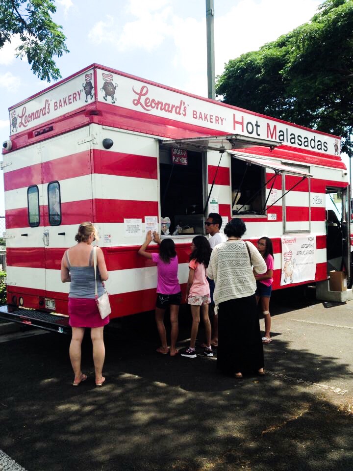 Image of a red and white striped vehicle selling malasadas in Hawaii.