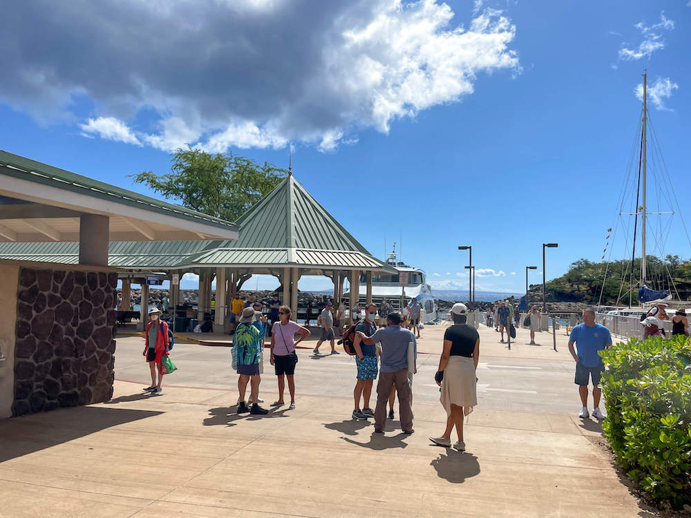 Image of some people standing around at a little boat harbor on Lanai island in Hawaii.