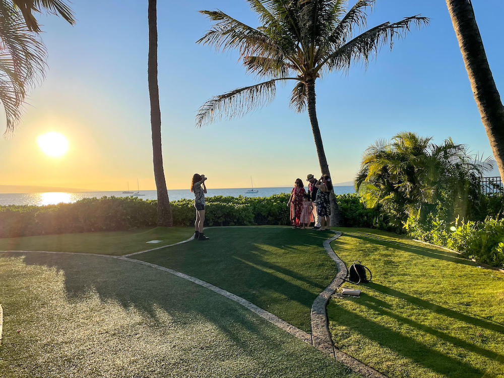 Image of a photographer taking a family photo at sunset on Maui.