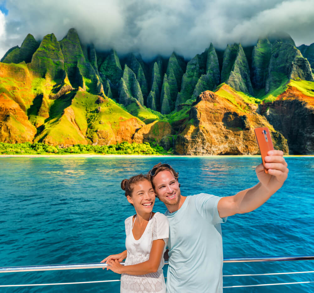 Image of a couple taking a selfie on a boat along the Na Pali Coast on Kauai