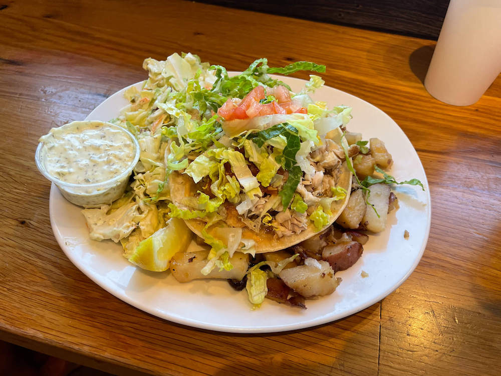 Image of a plate of fish tacos, homemade tartar sauce, and potatoes.