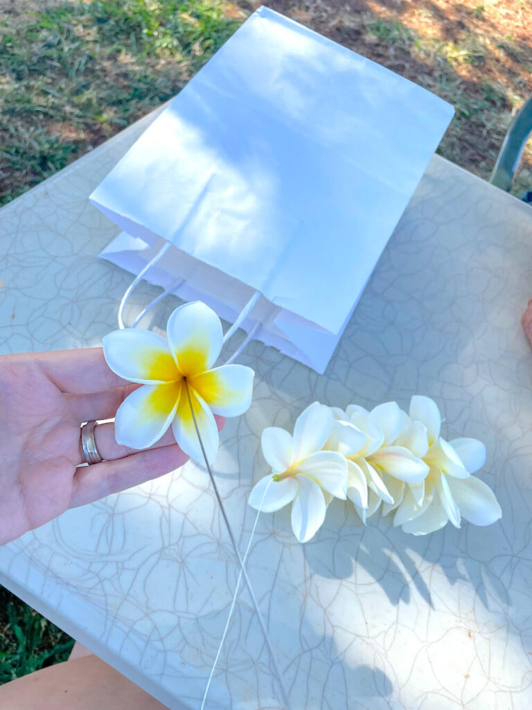 Image of someone stringing a lei with a needle and thread.