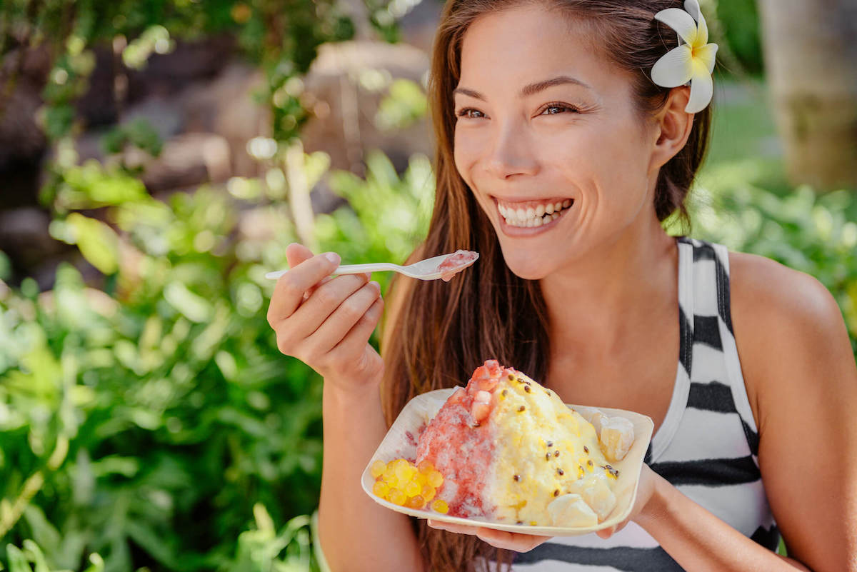 Find out where to eat on Oahu by top Hawaii blog Hawaii Travel with Kids. Image of a woman eating shave ice.