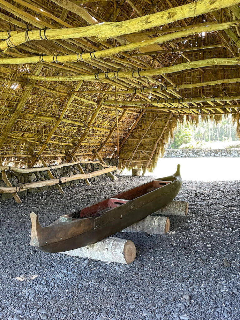 Image of a wooden canoe inside a thatched building on Maui.