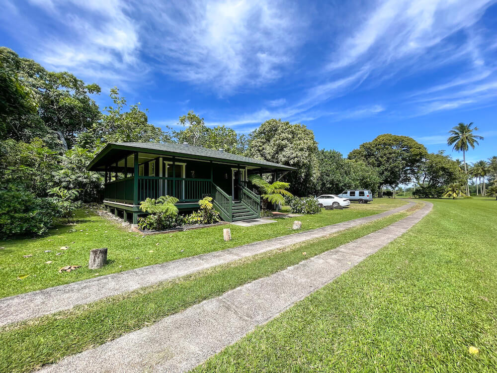 Image of a green plantation style building next to a rustic road at Kahanu Garden in Hana.