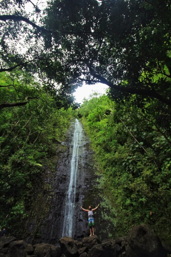 Image of a man with outstretched arms at Manoa Falls on Oahu.