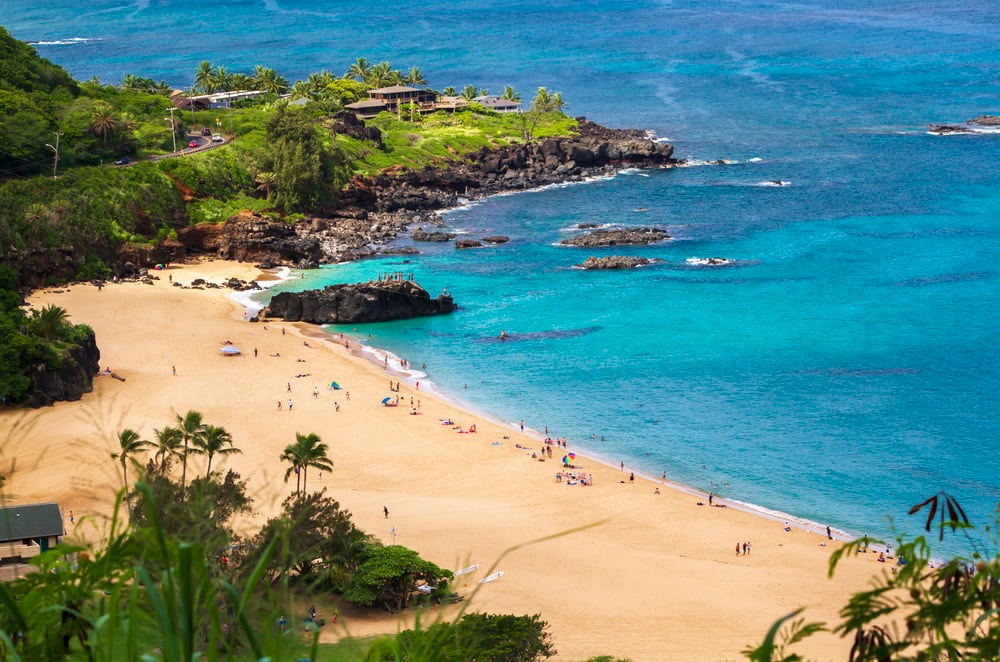 Image of a sandy beach with bright blue water in North Shore Oahu.