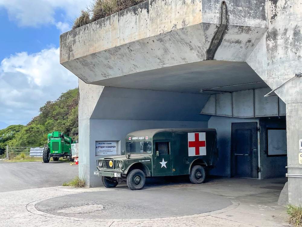 Image of a WWII bunker on Oahu with an old first aid truck out front.