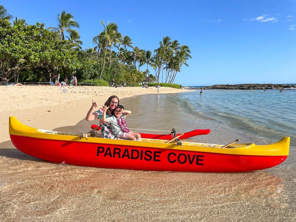 Image of a mom and son sitting in a Paradise Cove outrigger canoe.