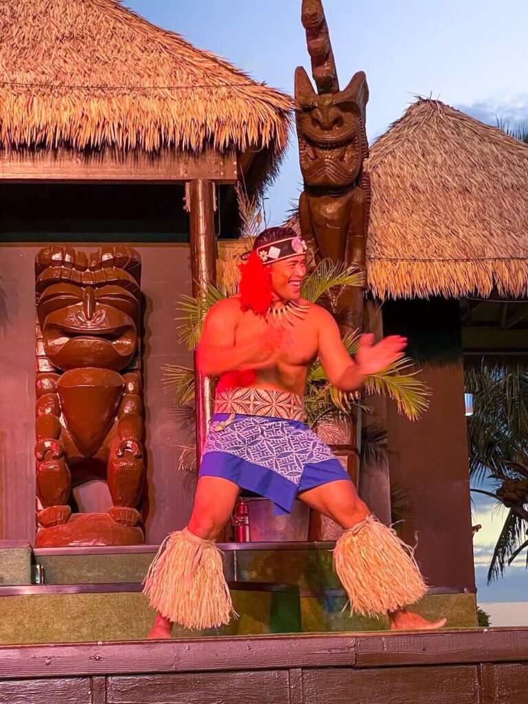 Image of a man wearing a sarong and grass decorations.