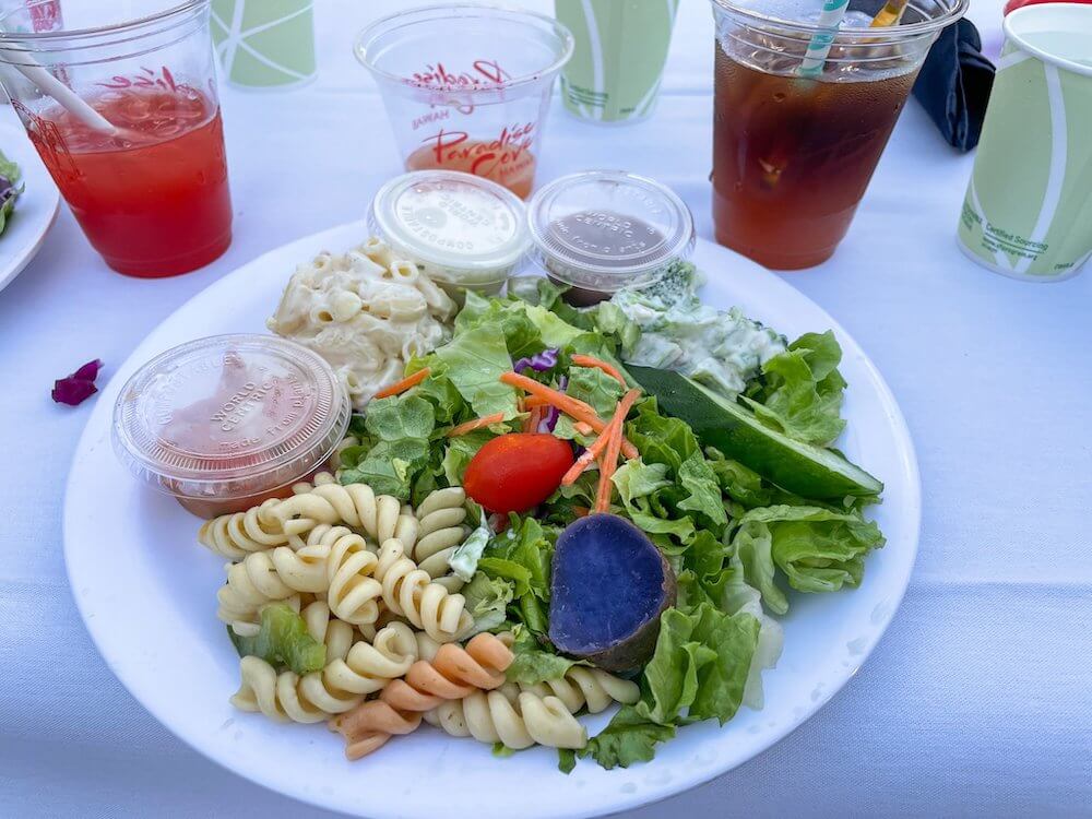 Image of a bunch of different salads on a plate at the Paradise Cove luau.