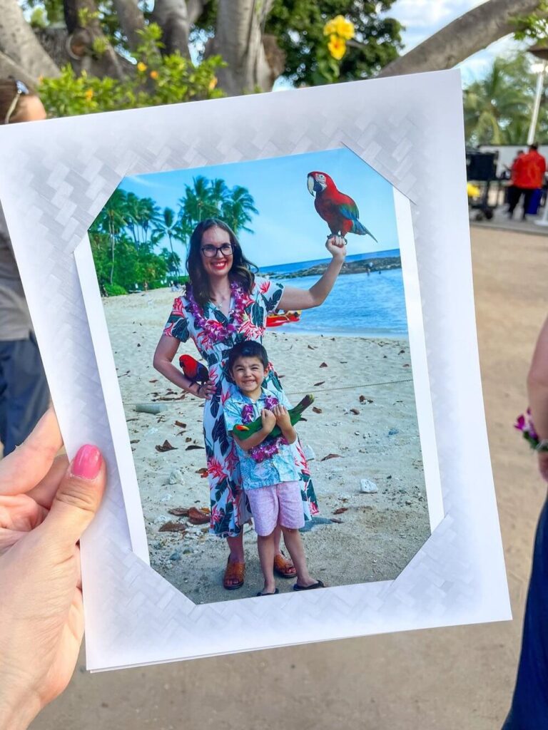 Image of a mom and son holding parrots in Hawaii.