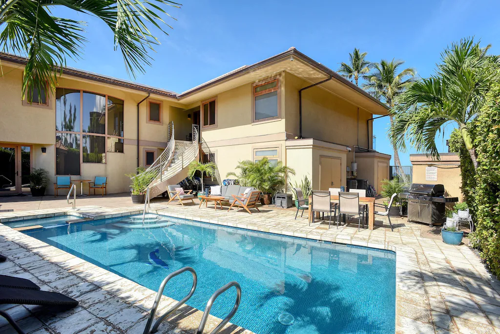 Image of a rectangular pool with a villa in the background