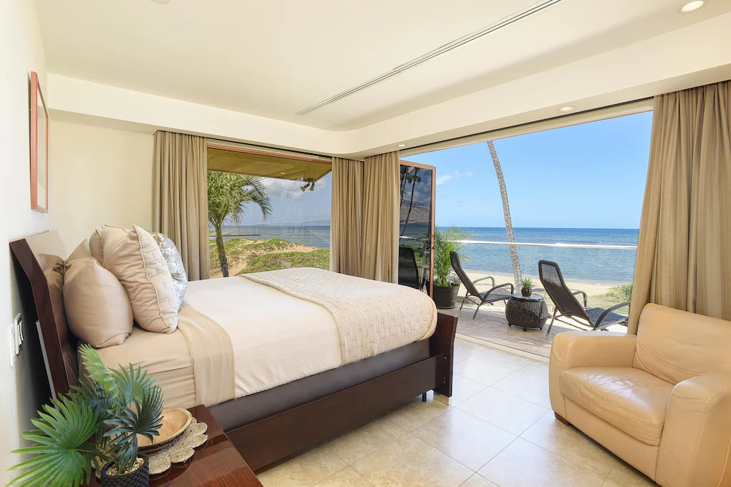 Image of a bedroom that opens up to a deck on the beach in Maui