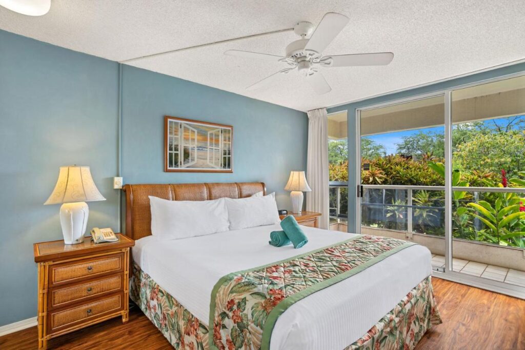 Image of a bright an airy tropical bedroom with lush greenery out the window