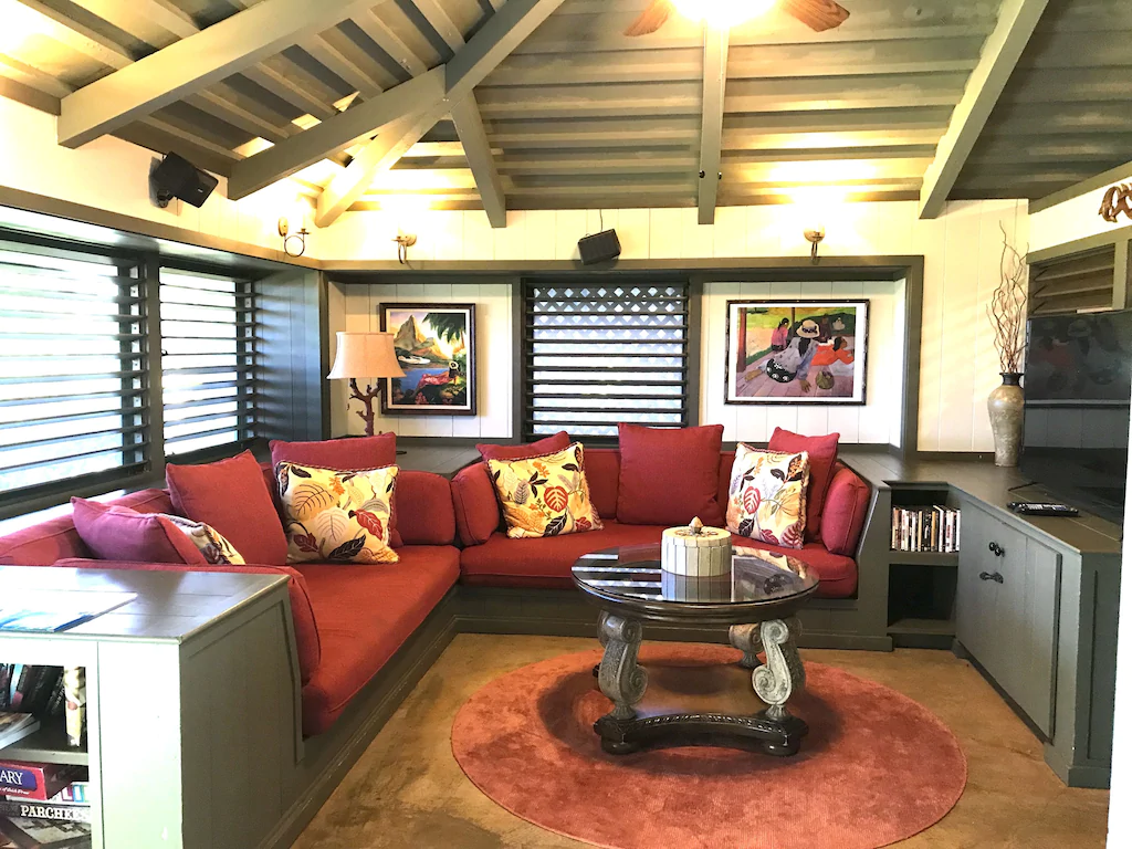 Image of red built in bench seats and little coffee table inside a cottage on Maui