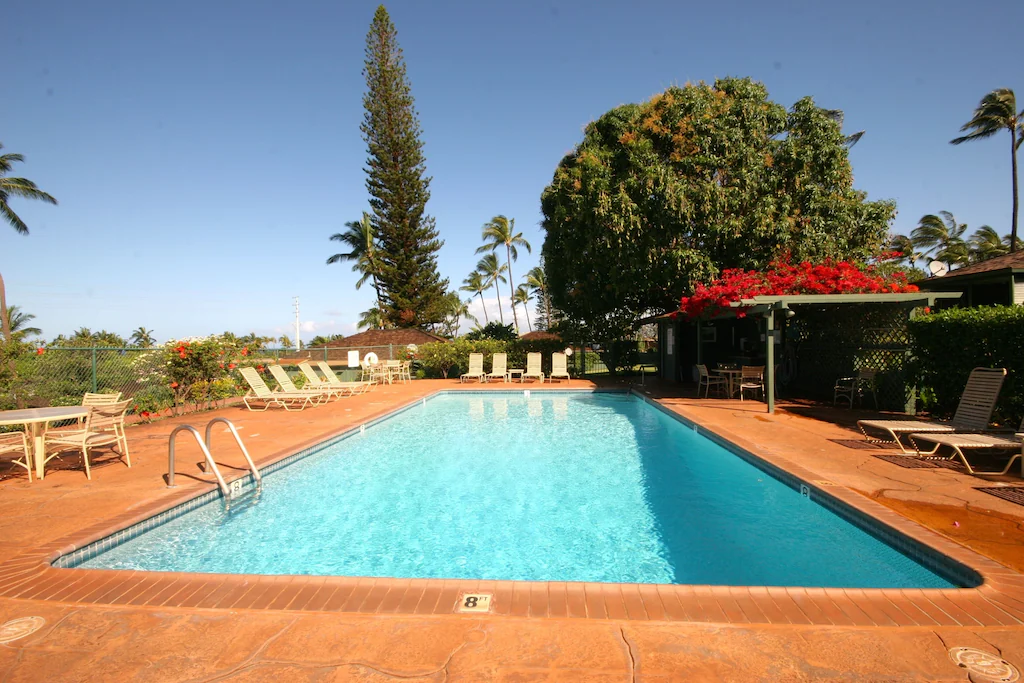 Image of a rectangular pool surrounded by deck chairs.