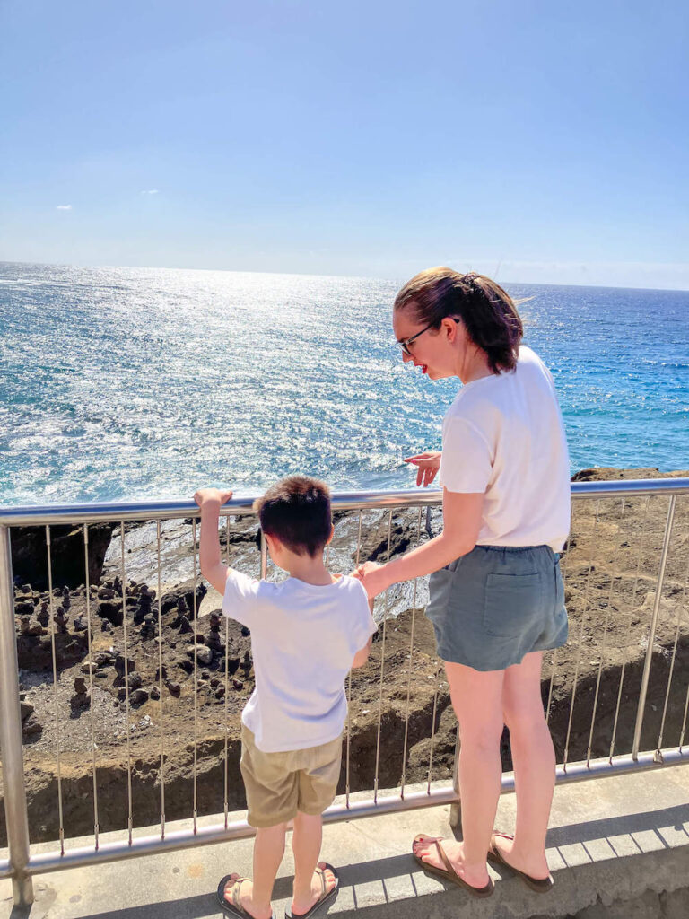 Image of a mom and son looking out at the calm ocean at Halona Blowhole