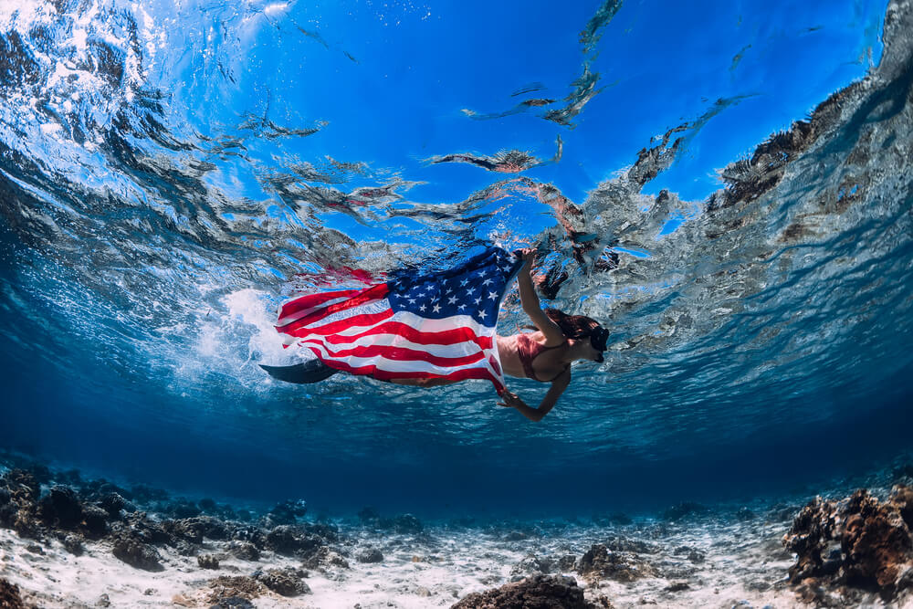 Image of a woman swimming with an American flag