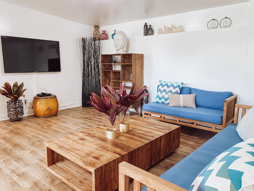 Image of a minimalistic living room with wood floors and futon style couches