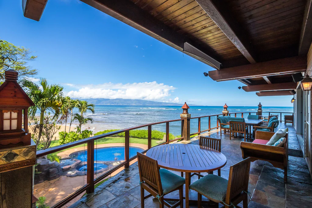 Image of a huge wrap around deck overlooking a pool and the ocean.