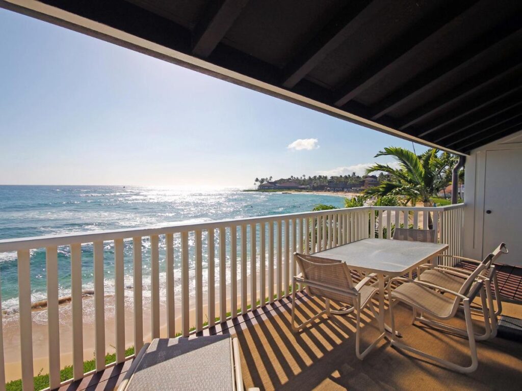 Image of a deck with a table and chairs overlooking the beach