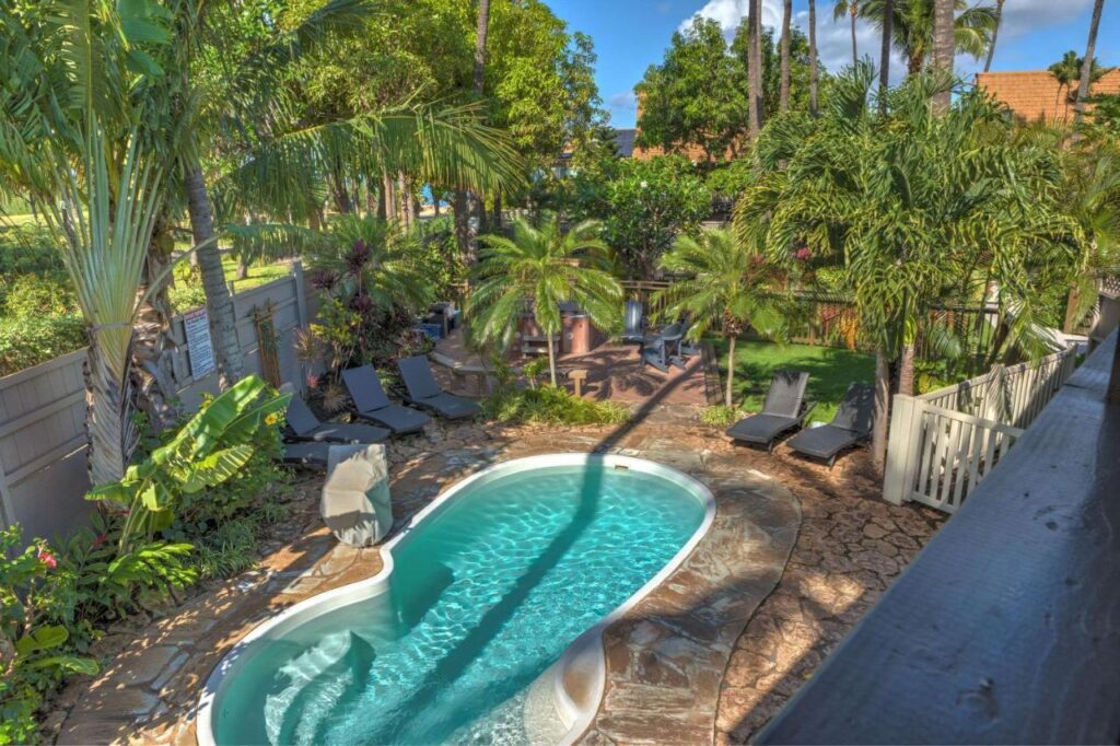 Image of a small kidney shaped pool surrounded by lush greenery