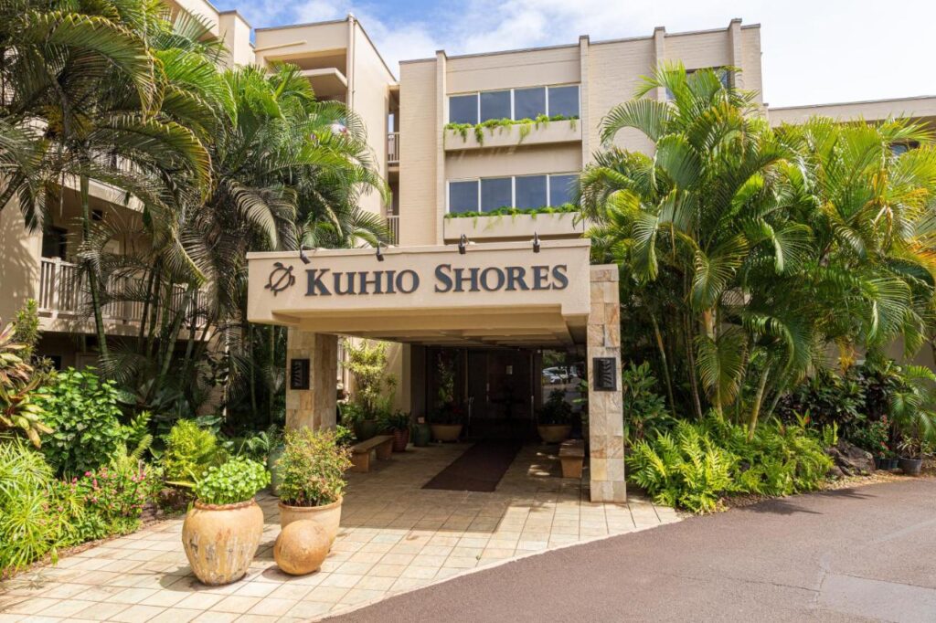 Image of the Kuhio Shores sign surrounded by palm trees