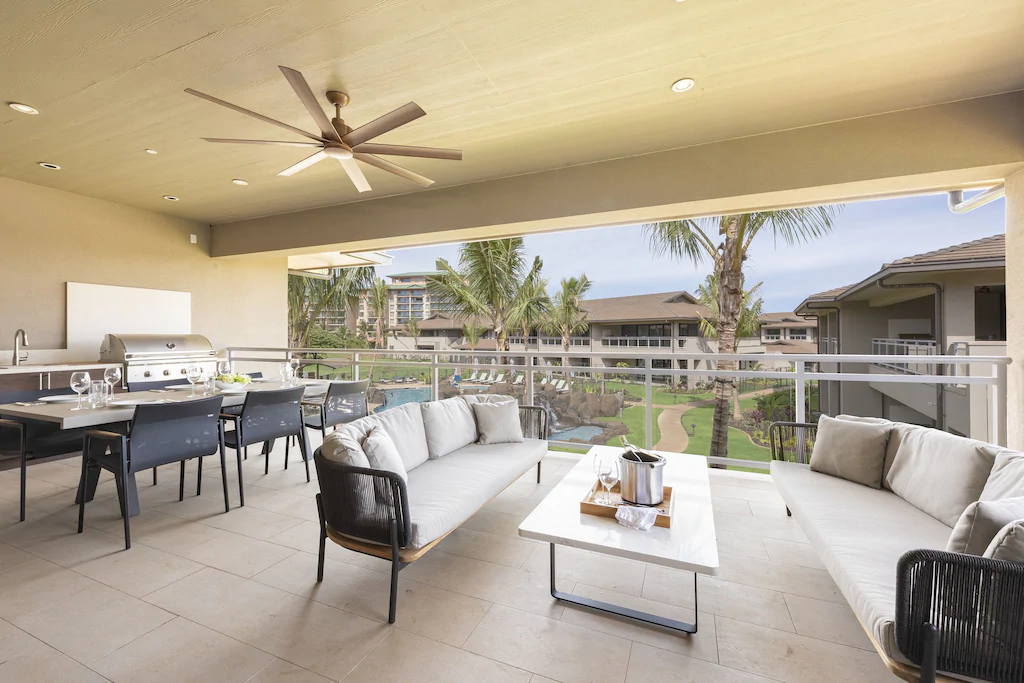 Image of couches and a dining area with open air out to a lanai