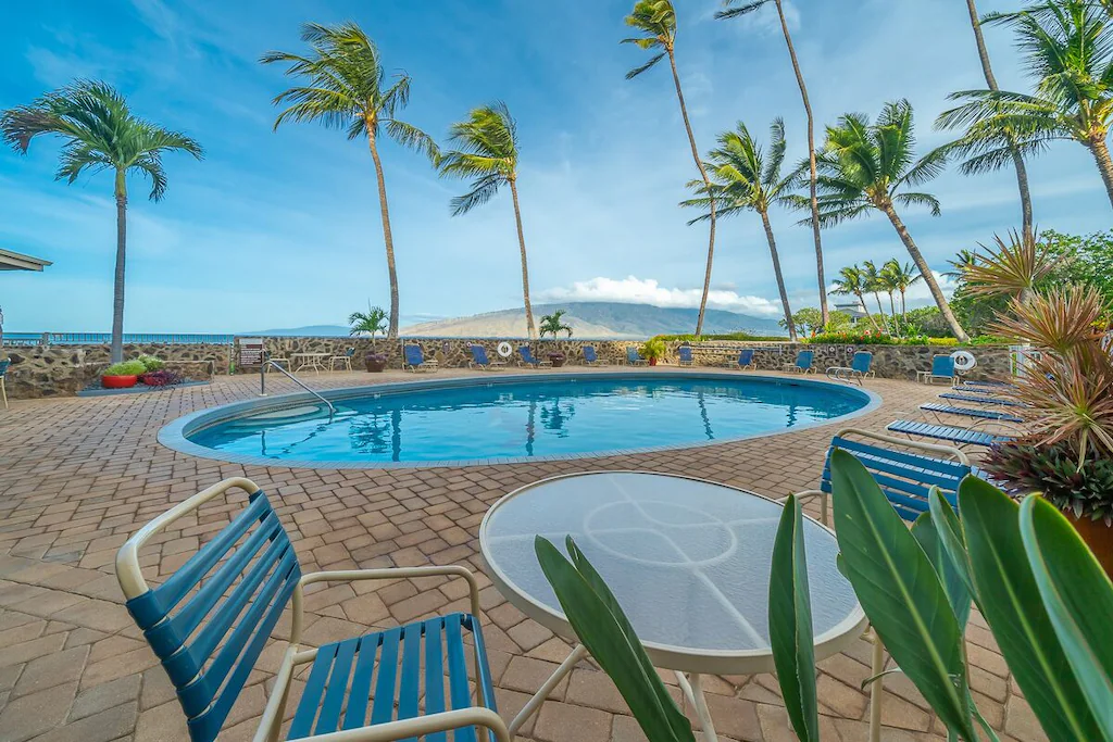 Image of an oval pool surrounded by palm trees in Kihei Maui