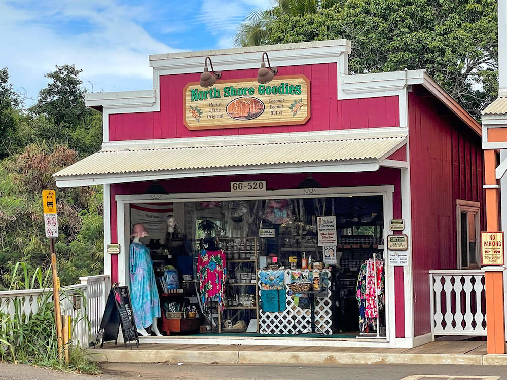 Image of a red building filled with Hawaiian clothing and souvenirs with North Shore Goodies sign on top