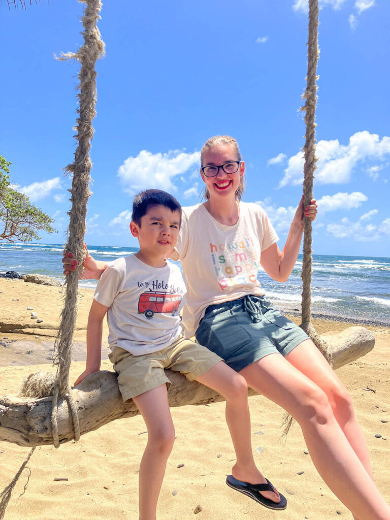 Image of a mom and son sitting on a beach swing on Oahu