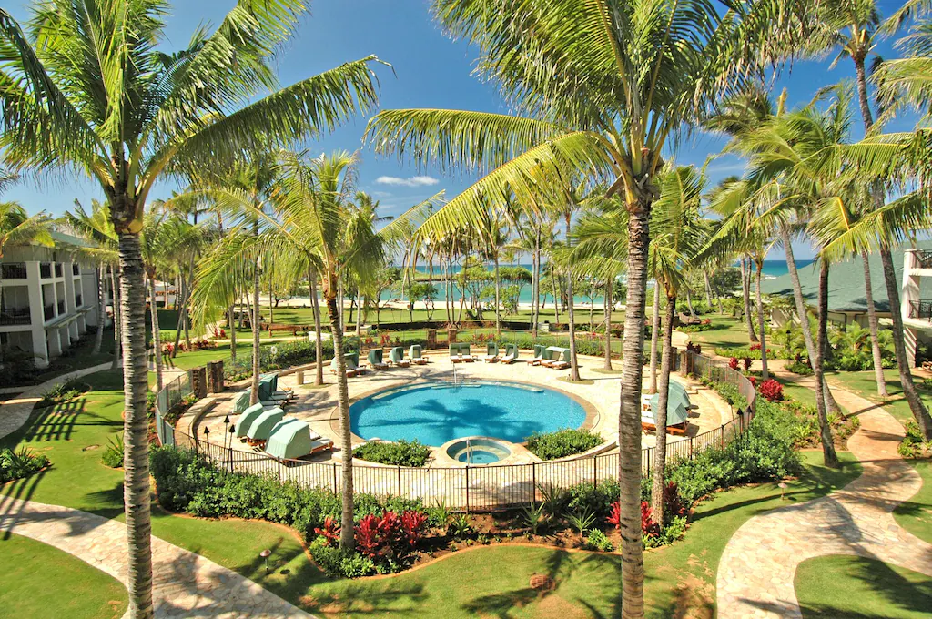 Image of a round pool surrounded by palm trees and paths at the Turtle Bay Resort