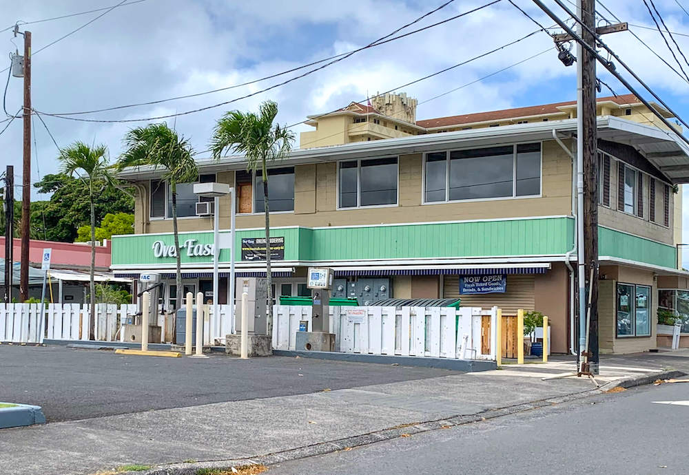 Image of a brown building with green trim with the Over Easy sign on it