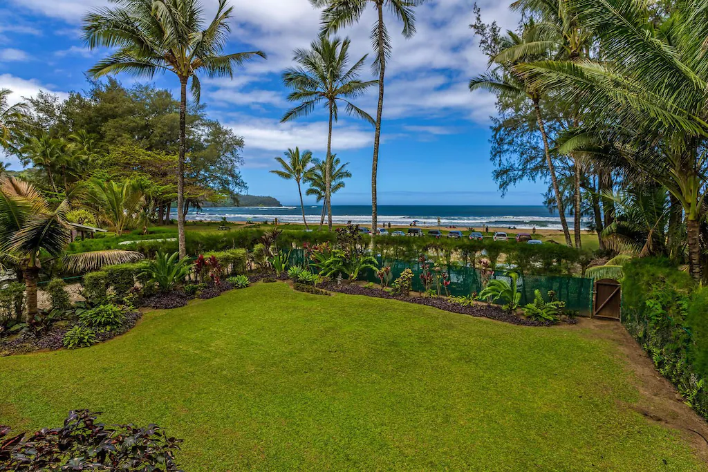Image of a large grassy lawn in front of a KAuai beach