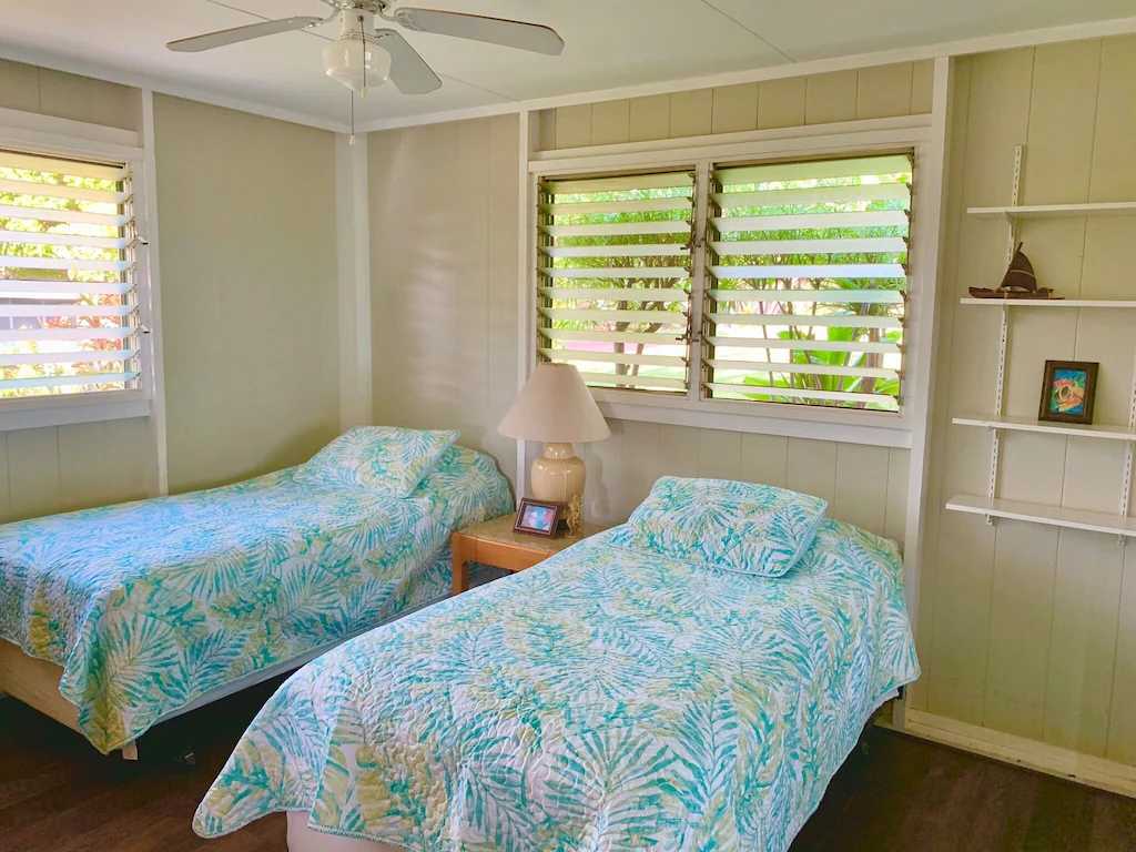 Image of two twin beds with tropical bedspreads at a Maui cottage