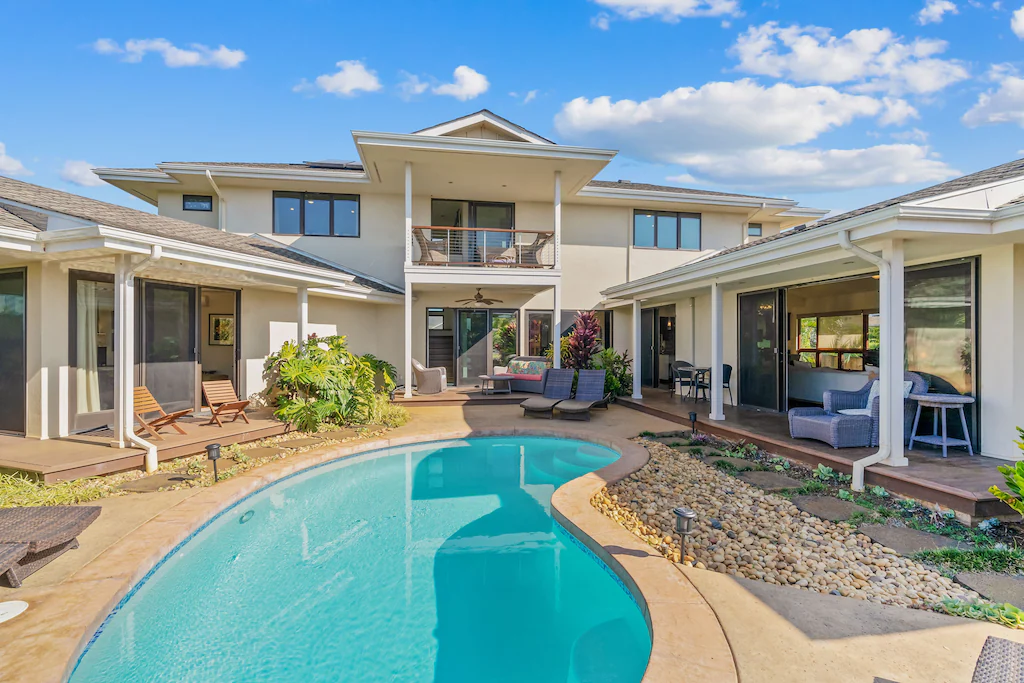 Find out the best Kauai luxury vacation rentals recommended by top Hawaii blog Hawaii Travel with Kids! Image of a large white house with a pool in the back