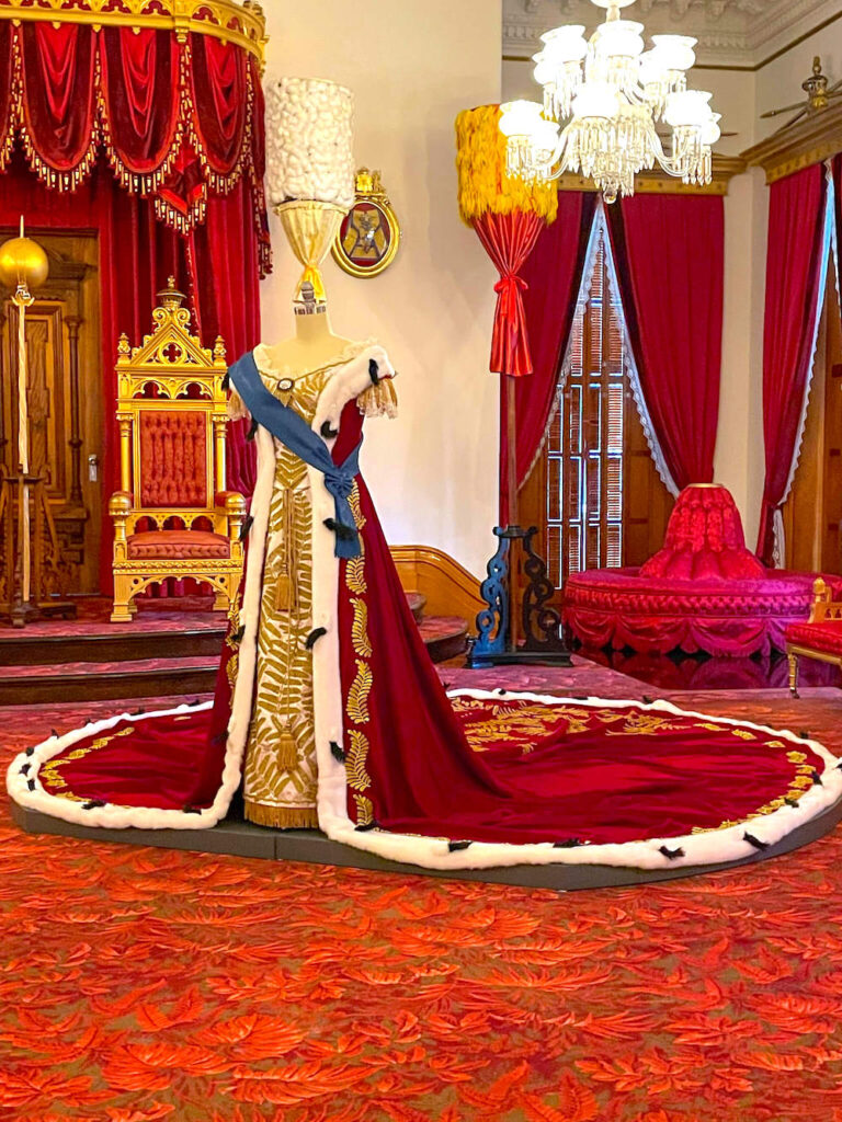 Image of a red ballgown with a huge train at Iolani Palace in Hawaii.