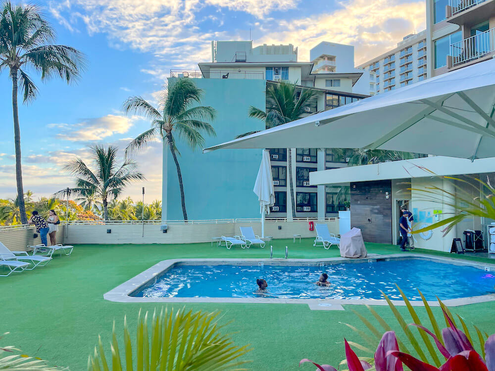 Image of a small pool surrounded by astroturf at a rooftop pool in Waikiki.