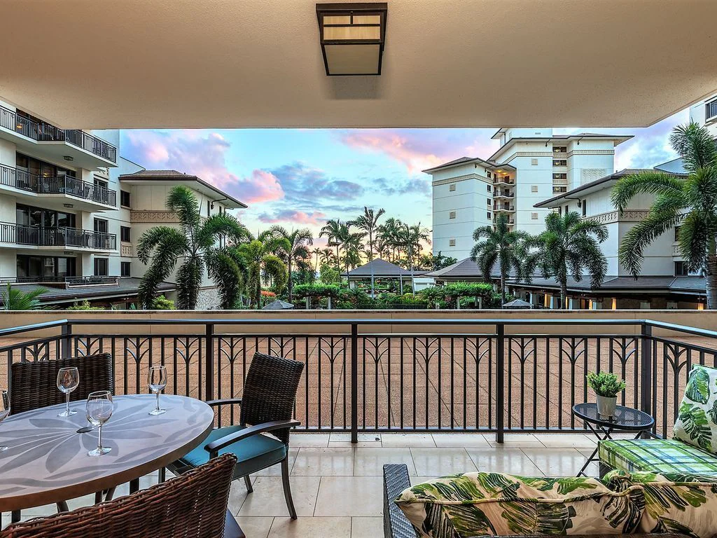 Image of a large lanai overlooking palm trees and buildings at the Oahu vacation rental for large groups