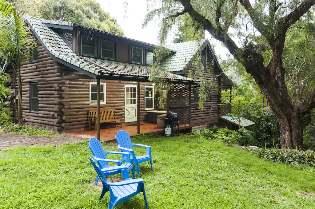 Image of blue adirondack chairs in front of a log cabin in Hawaii