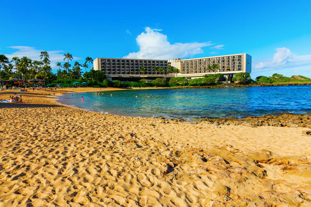 Image of a golden beach with a resort in the background.