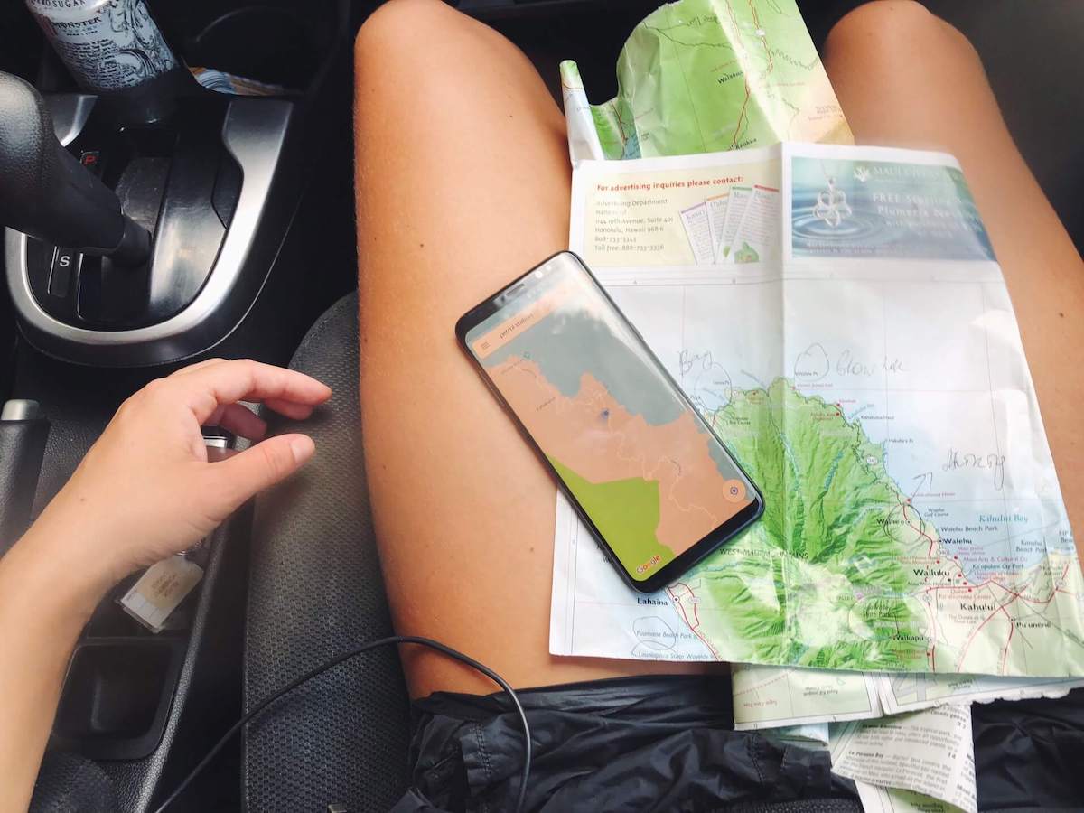 Find out how to get from Kahului Airport to Lahaina by top Hawaii blog Hawaii Travel with Kids Image of a Maui map on a woman's lap in a car