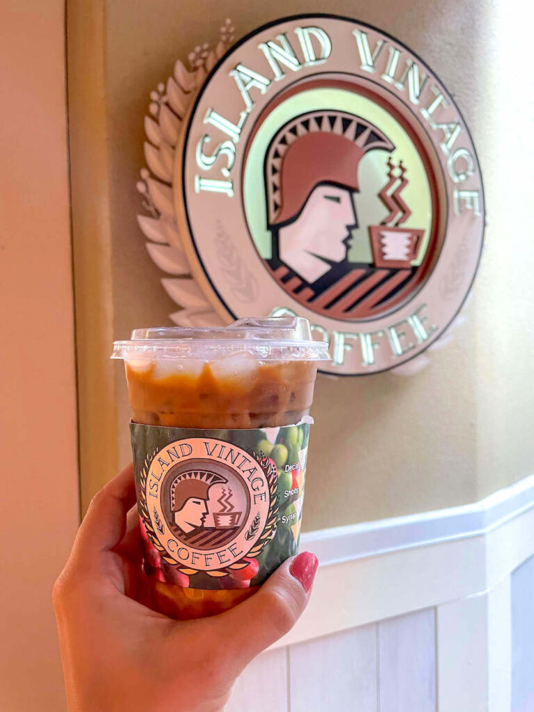 Image of an Island Vintage Coffee to go cup in front of the Waikiki coffee shop sign