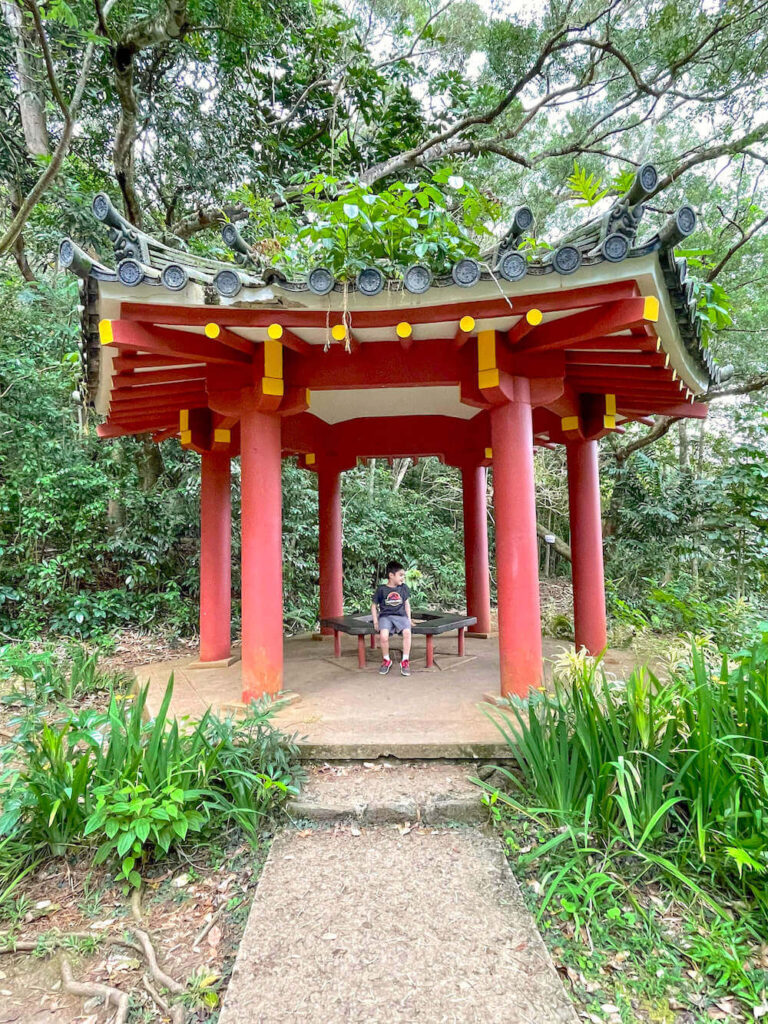 Image of a boy sitting inside an Asian-style pavilion at the Byodo-In Temple on Oahu