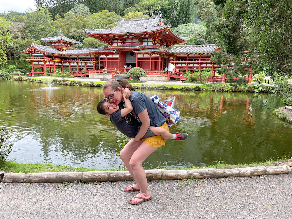 Image of a mom and boy snuggling in front of a Japanese temple in Hawaii