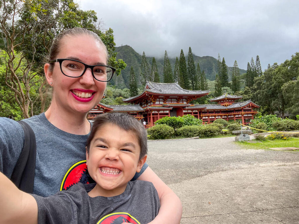 Image of a mom and boy taking a selfie with a Japanese temple in the background